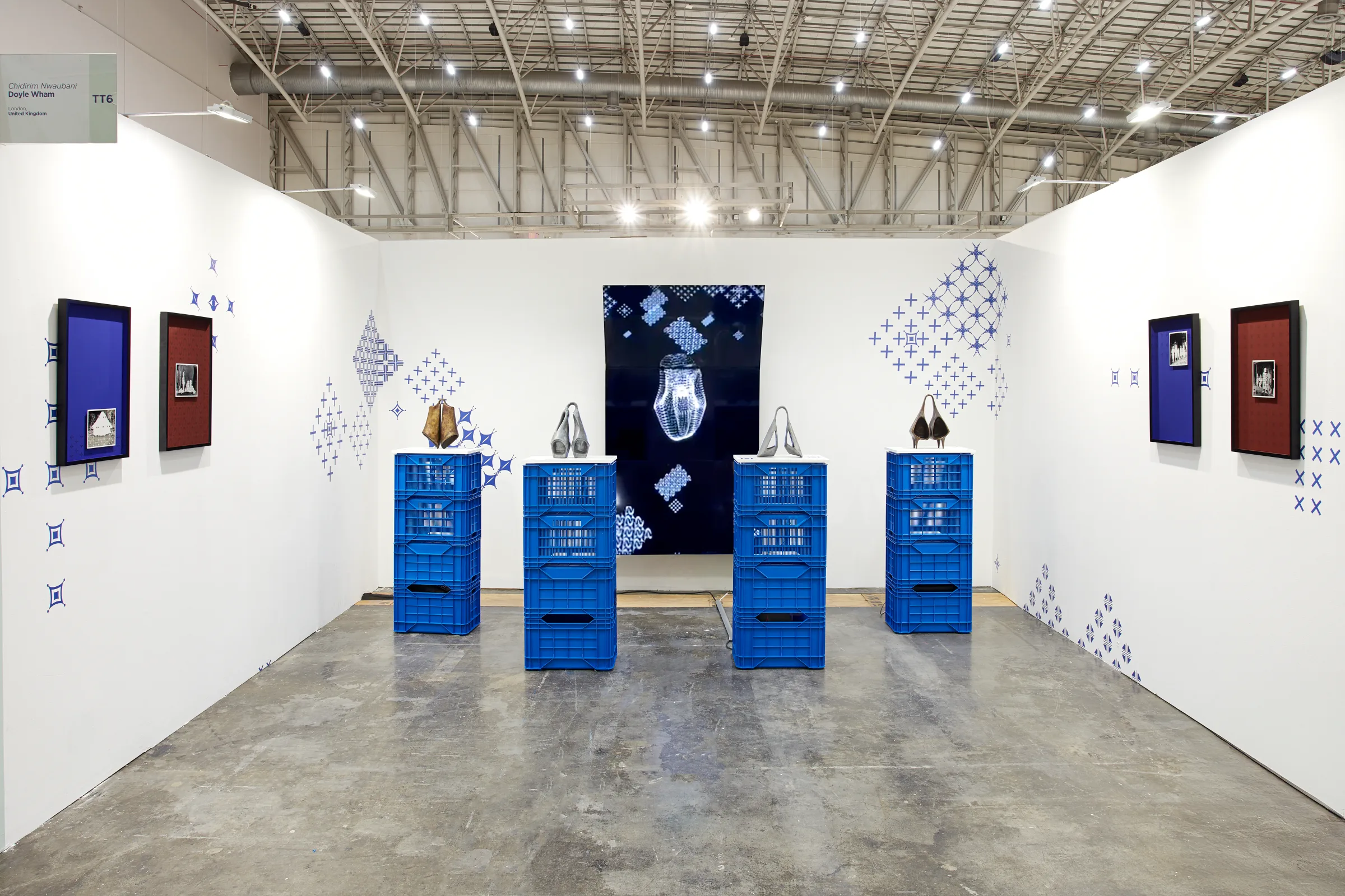 The Doyle Wham booth at Investec Cape Town Art Fair — four bronze ogene on blue crates before a generative screen