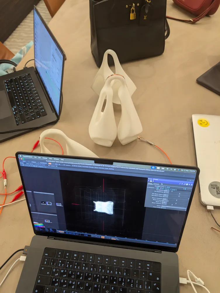 The form running as a point cloud in TouchDesigner next to the printed prototypes