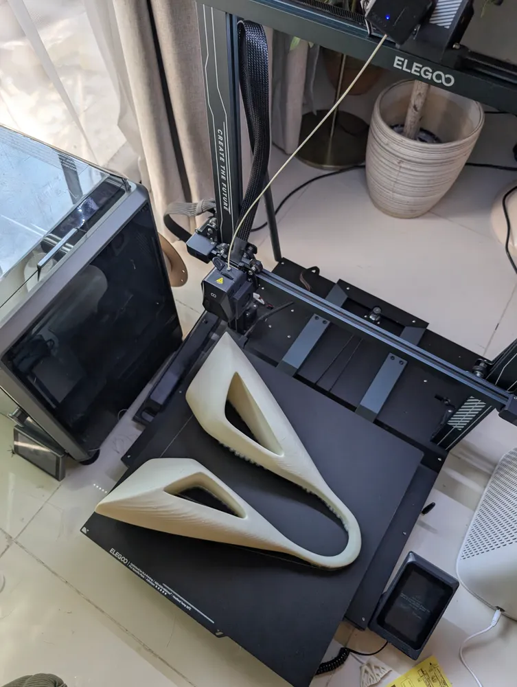 A shell of the form coming off the bed of an ELEGOO 3D printer