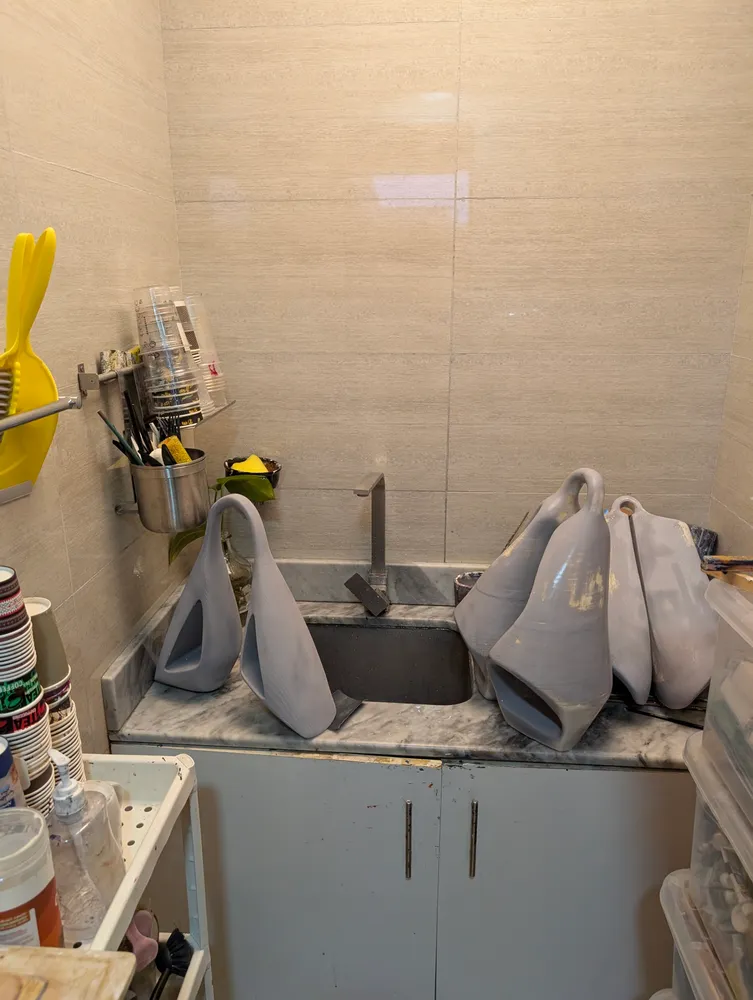 Grey-primed casts drying beside the studio sink